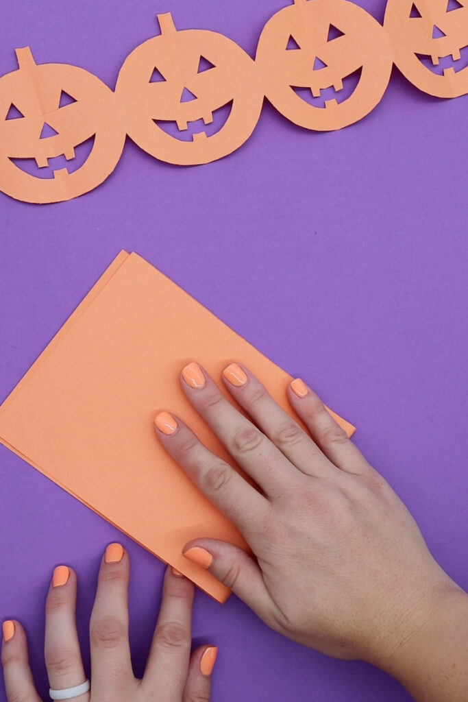 folding orange paper for pumpkin paper chain